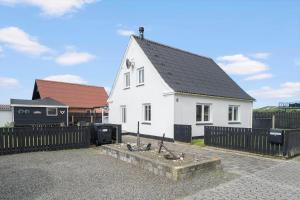 a white house with a black roof and a fence at 704-Thyboron-Kirkevej-6 in Thyborøn