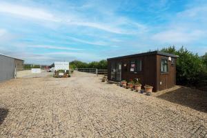 a small building with potted plants on a gravel lot at Private & Peaceful Double Ensuite Rooms in Stapleford in Stapleford