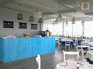 ガビッチェ・マーレにあるHotel Maremontiの青いカウンター、テーブル、椅子が備わるレストラン
