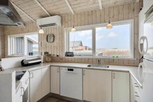 a kitchen with white cabinets and a large window at 528-Lemvig-Stranden-22 in Lemvig