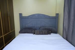 Una cama con cabecera negra y dos almohadas. en Jamin Homes AD2, en Ruiru