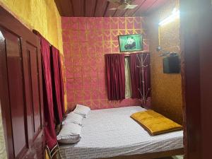a small bed in a room with red walls at Periyar Cottage in Munnar