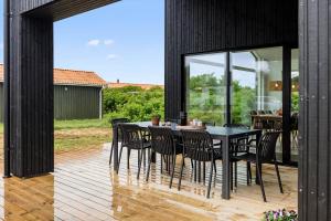 comedor con mesa y sillas en la terraza en 279-Harboore-Neerlandiavej-72, en Harboør