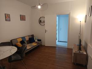 a living room with a couch and a table at Appartement Saphir 2-4 pers - L' Artdu'Net - in Sedan