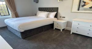 Un dormitorio con una cama grande y una mesita de noche. en Southcrest Manor Hotel, Best Western Signature Collection, en Redditch