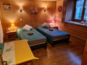 a room with two beds and a table and two lamps at Gîte de l Auguille in Megève