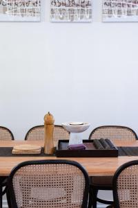 Una mesa de comedor con sillas y una pared blanca. en The View at Kingston Beach, en Kingston Beach