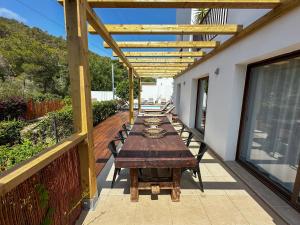 Un patio con una mesa larga en una terraza. en Villa Ibiza Retreats, en Puig D’en Valls 5 fotos más