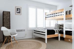 Un dormitorio con una litera y una silla. en The View at Kingston Beach, en Kingston Beach 62 fotos más
