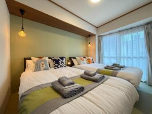 Un dormitorio con dos camas y una ventana. en nestay apartment tokyo akihabara, en Tokio
