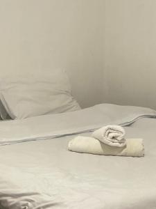 a white towel sitting on top of a bed at Hidden Gem 32 acre road in Nairobi