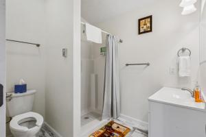 une salle de bain blanche avec douche et toilettes dans l'établissement Merlot Cottage - GOTL Strip - Lover's Retreat, à Geneva