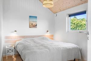 a white bedroom with a bed and a window at G245-Lemvig-Porsevej-45 in Lemvig