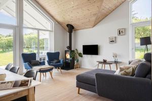 a living room with a couch and chairs and a tv at G245-Lemvig-Porsevej-45 in Lemvig