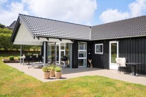 a black and white house with a patio at G245-Lemvig-Porsevej-45 in Lemvig