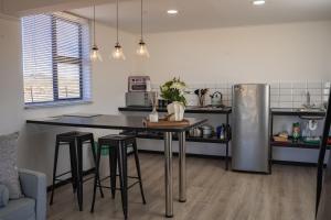 a kitchen with a table and a refrigerator at Kénōsis Guestfarm - Chalet in Springbok