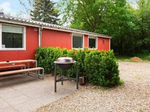 a barbecue grill in front of a red house at 20 person holiday home in Herning in Herning