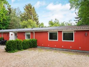 a red house with trees in the background at 20 person holiday home in Herning in Herning