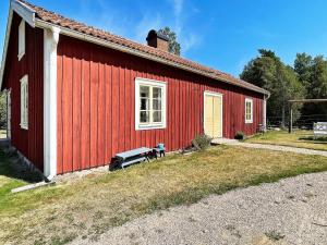 a red building with a bench in front of it at 4 person holiday home in Furuby in Furuby
