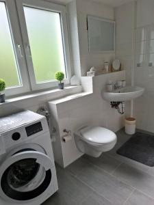 a bathroom with a washing machine and a sink at De Hecksche Stuuv in Kreuztal +7 photos