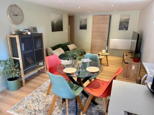 a living room with a table and colorful chairs at Appartement moderne, neuf et tout confort in Sundhoffen