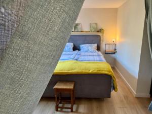 a bedroom with a bed with a blue and yellow blanket at Appartement moderne, neuf et tout confort in Sundhoffen