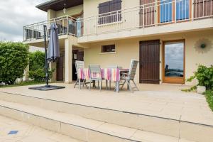 Un patio con una mesa y sillas y una sombrilla. en Appartement 70m2 à 10 minutes de Lyon adapté PMR, en Saint-Genis-Laval