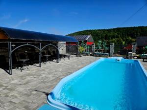 a large blue swimming pool next to a building at Apartamenty pod Gromadzyniem in Ustrzyki Dolne