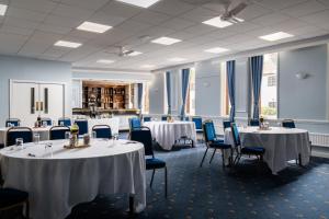 a conference room with tables and chairs and tablesearcher at The Cathedral Hotel in Lichfield