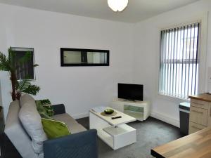 a living room with a couch and a tv at Central Location 1 Double Bedroom Apartment 7 in Blackpool