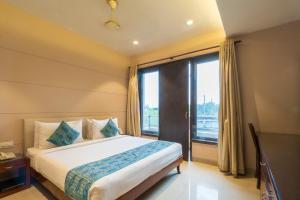ニューデリーにあるCosy Grand, Chanakyapuri by The Cosy Hotelsのベッドと大きな窓のある寝室 +87枚の写真