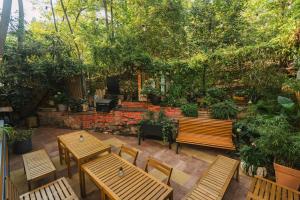 a patio with wooden tables and chairs and trees at Hostel Elf in Prague +35 photos