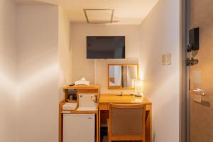 a room with a desk with a sink and a mirror at Front Desk-less Fitness Hotel Iroha in Kishiwada