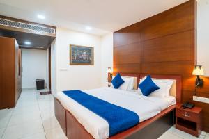 a bedroom with a large bed with blue pillows at Hotel Astravista in Jaipur +40 photos