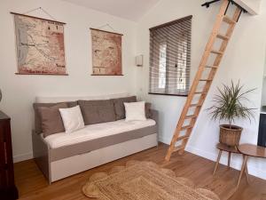 a living room with a couch and a ladder at La petite maison de Boisrival in Bury