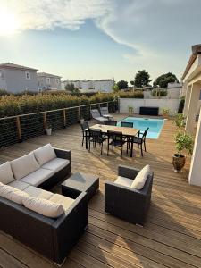 une terrasse avec des canapés, une table et une piscine dans l'établissement Villa Gina, à Garons
