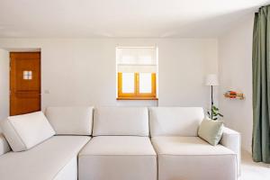 a white couch in a living room with a window at Casa Pradiei Dolomiti View in Cavareno