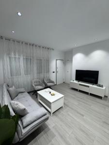 un salon avec un canapé et une télévision dans l'établissement Apartamento AEROPUERTO12, à Coslada 5 autres photos