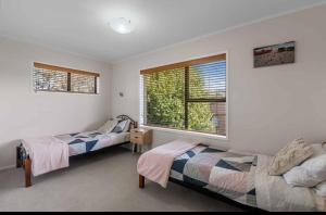 a bedroom with two beds and a window at Spacious retreat with Mountain View in Rotorua