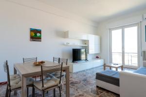 a kitchen and living room with a table and a couch at Appartamento Clizia in Pescara