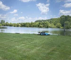 a picnic table in the grass next to a lake at Fisherman’s Dream in McArthur