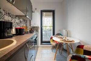a kitchen with a counter and a table with chairs at Plaza Residence Studio 197 in Bucharest