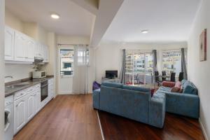 un soggiorno con un divano blu e una cucina di Golden Star AV a Funchal