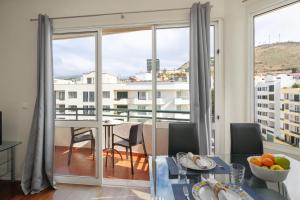 un soggiorno con tavolo da pranzo e ampia finestra di Golden Star AV a Funchal