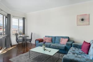 un soggiorno con un divano blu e un tavolo di Golden Star AV a Funchal