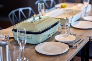 a table with an open suitcase on a table with plates and glasses at TOCORO Mt Fuji Shizuku in Fujikawaguchiko