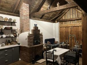 a living room with a brick fireplace and a table at Lajtorjás in Őriszentpéter