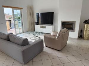 a living room with two couches and a flat screen tv at Luxury 6BR Villa Private Pool & Games Room Sleeps 12 in Quarteira