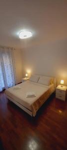 ein Schlafzimmer mit einem großen Bett mit zwei Nachttischen in der Unterkunft Casa Niky 