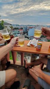 a group of people sitting at a picnic table drinking beer at Kha Bản Homestay in Cao Bằng
